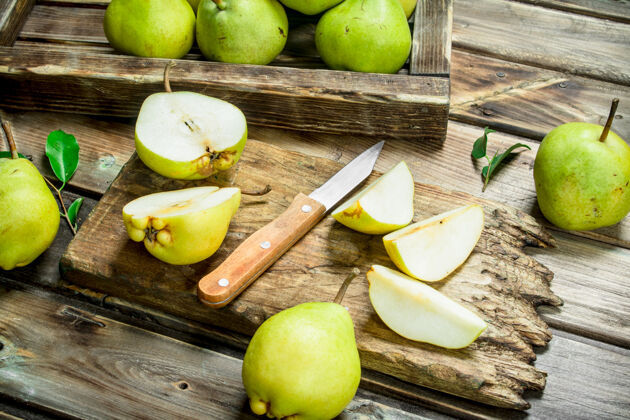 四分之一把新鲜的梨放在托盘里 把切成片的梨放在砧板上 用刀放在木桌上生切片零件