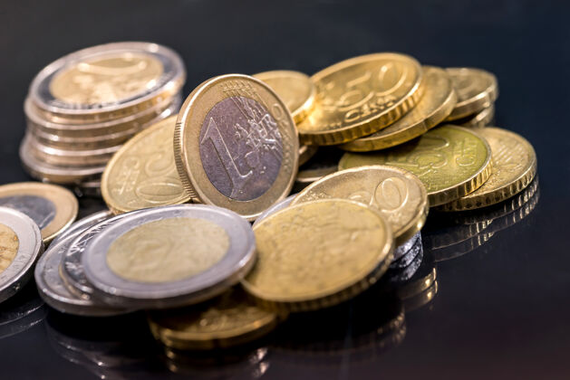 无序黑色桌子上有很多欧元硬币圆金融货币