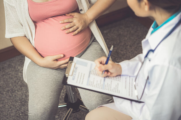 医生快乐的孕妇到医院或诊所找妇科医生做妊娠顾问婴儿孕妇患者