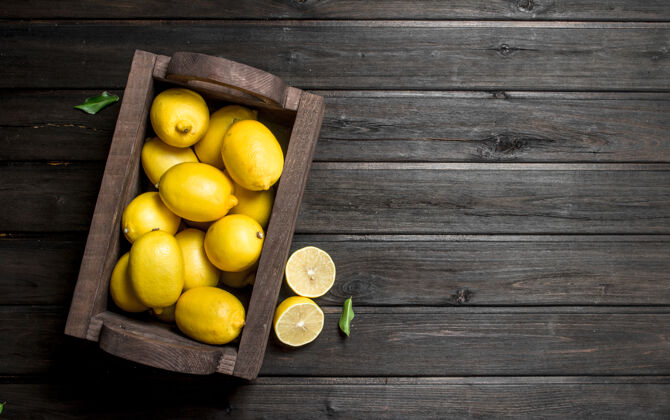 顶部木桶里新鲜柠檬的味道盒子打开黑木桌配料切割柑橘