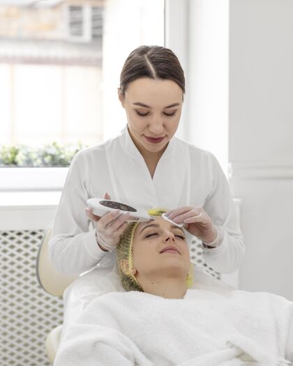 美容常规在美容诊所做面部护理的女人面部护理美容院化妆品