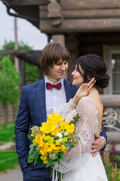 乡村新婚夫妇在豪华木屋附近摆姿势参加婚礼进入年轻俄罗斯
