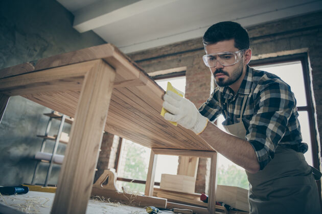 眼镜低视角集中人硬木工人更新木家具板表抛光光滑的表面在家房子车库木材手工