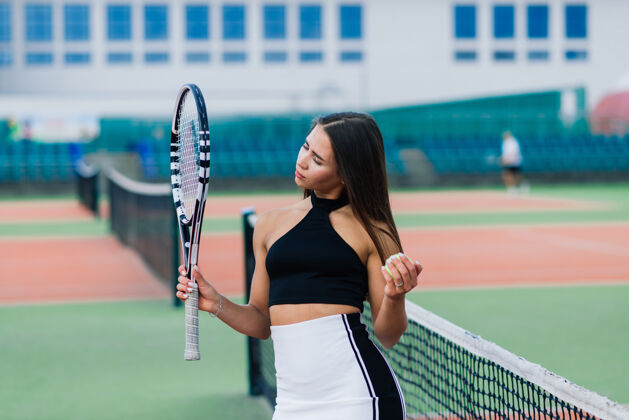 装备在网球场上穿着时髦运动服的漂亮性感女人运动运动穿着