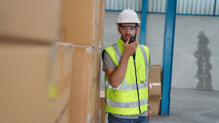 工人专业货运工人通过便携式无线电与他人联系工人工厂和仓库沟通理念无线电建筑设施