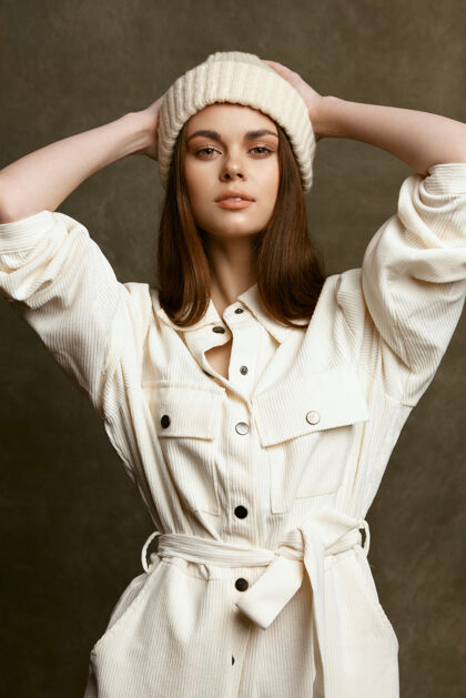 年轻人穿着工作服的时髦女模特手把手放在头和帽子后面白种人魅力优雅