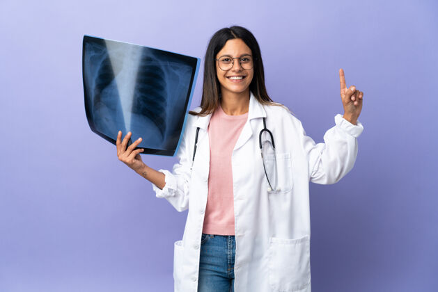 医院年轻的女医生拿着一张X光片 举着一个手指表示最好专家诊所号码