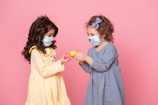 可爱两个戴着粉红色彩蛋保护面具的女孩医疗保健复活节童年