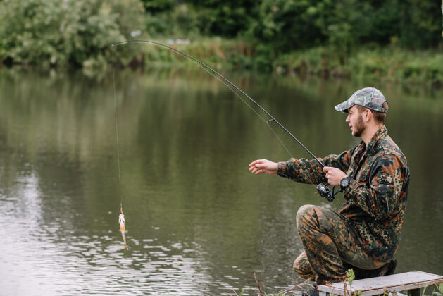 自然一个渔夫拿着鱼竿在河岸上渔民活动休闲