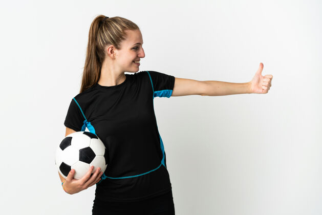 球一个年轻的足球运动员 一个被隔离在白色背景下竖起大拇指的女人成功足球姿势