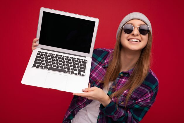 职业照片中 美丽的年轻女子手持电脑笔记本 看着被五颜六色隔离的相机背景.copy空间在线游戏上网本