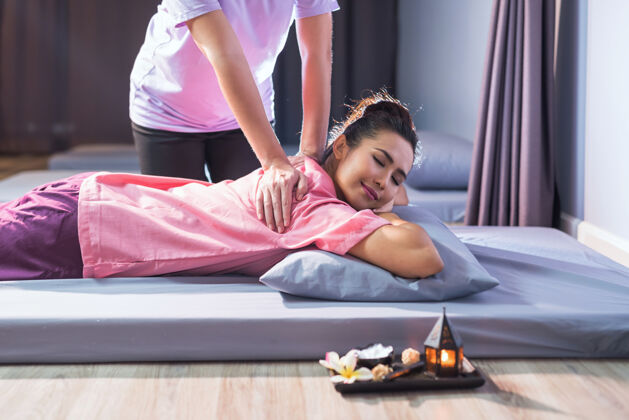 护理泰式床上按摩疗法 为年轻美丽的亚洲女子在水疗中心沙龙.健康关心和放松来治疗疼痛概念备选方案医疗行业治疗压缩保湿