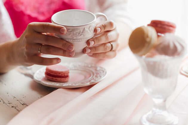 早上喝早茶的女孩咖啡手特写镜头和蛋糕人茶女人