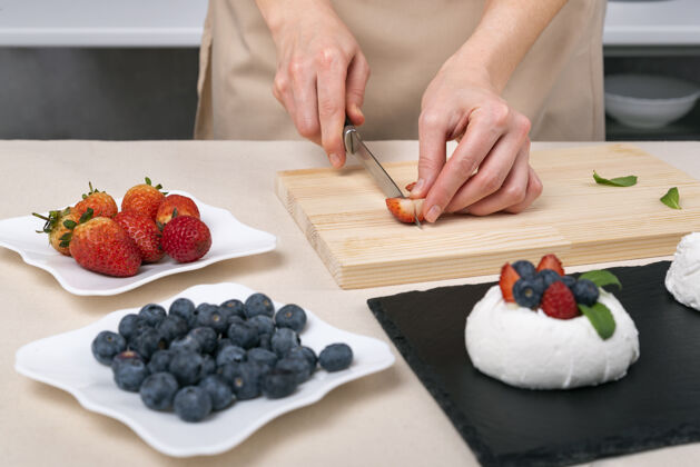 奶油浆果制作工艺蛋糕.女士手切草莓来装饰甜点自制草莓装饰