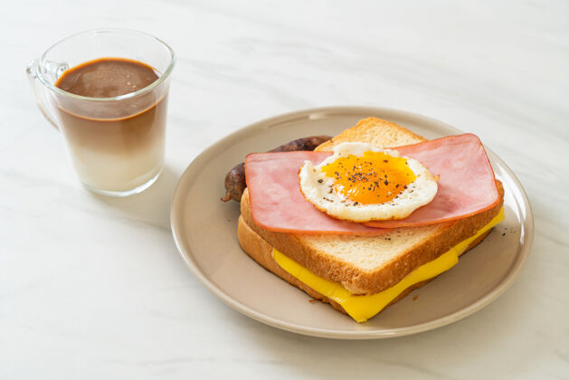 切片自制面包烤奶酪火腿煎蛋配猪肉香肠和咖啡当早餐女士早上丰盛
