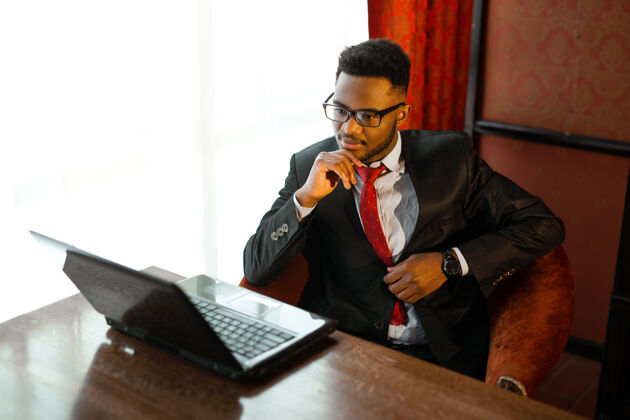笔记本帅气的非洲年轻人穿着西装 在室内拿着笔记本电脑老板专业执行