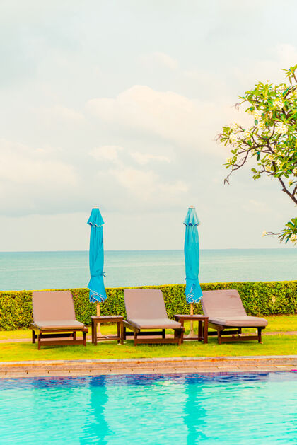 户外椅子游泳池和伞游泳池周围有大海景观岛屿放松