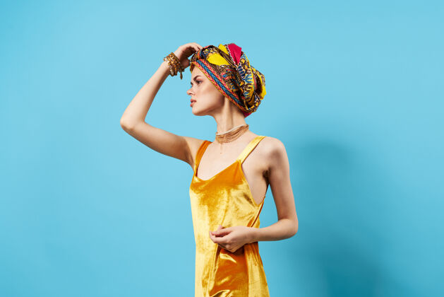 魅力穿着黄色连衣裙的女人头上戴着五颜六色的头巾装饰工作室的生活方式魅力护理肖像文化