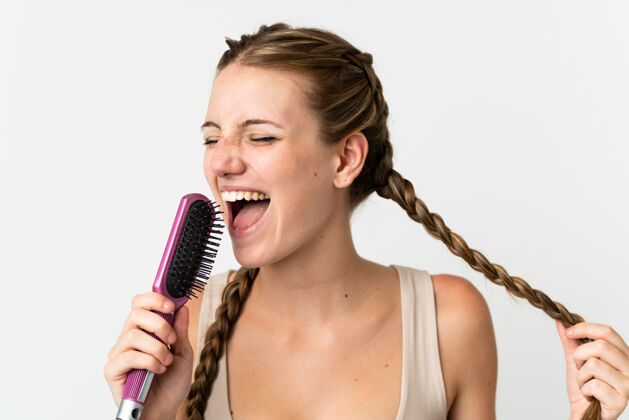 年轻人年轻的白种女人 戴着梳子 在白色的背景下唱歌声音音乐家娱乐
