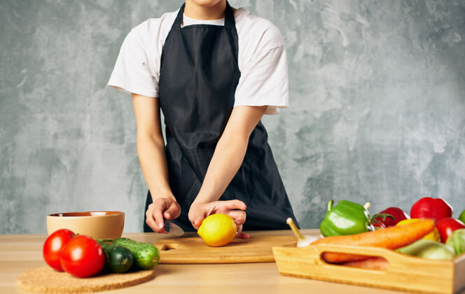 围裙穿黑围裙的女人切菜厨房煮新鲜食物桌子食物蔬菜