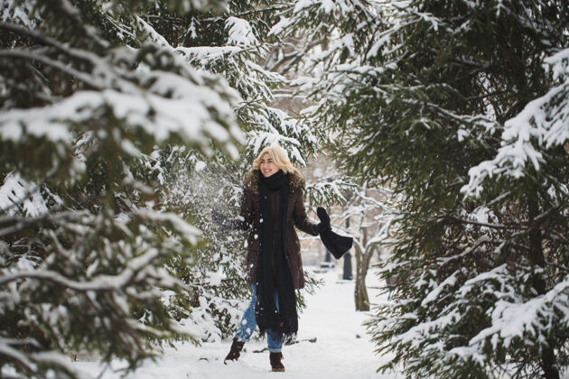 圣诞节美丽的女人在冬天的森林里摆姿势人雪女性