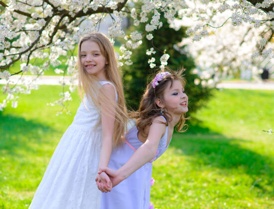 衣服美丽的年轻女孩 蓝色的眼睛 白色的裙子 在花园里 苹果树上 尽情享受快乐玩耍眼睛复活节