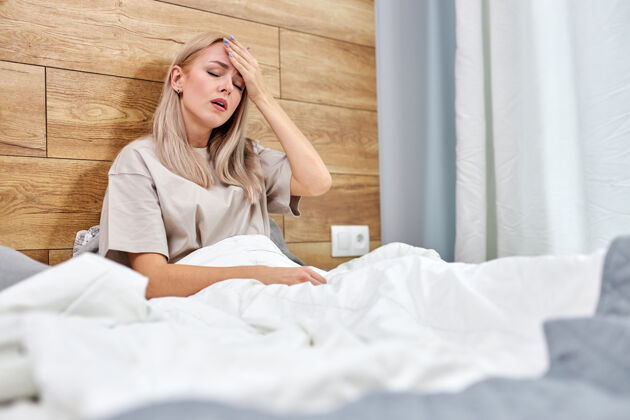 健康患流感的妇女独自坐在家里的床上 高烧或发烧 触摸额头冷流感和偏头痛 保健概念病毒房子成人