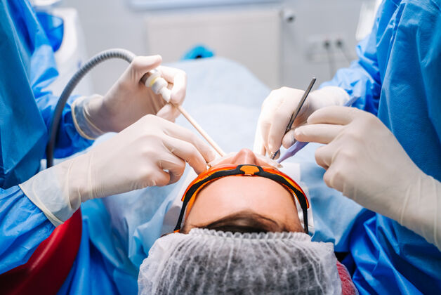 外科穿着制服的牙医在现代口腔诊所为病人进行牙科治疗健康技术外科