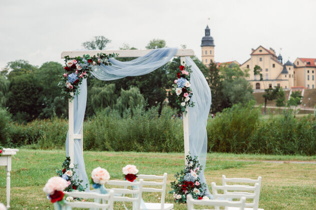 浪漫绿色街道上的婚礼草坪装饰用鲜花装饰拱门以庆祝仪式国家登记草