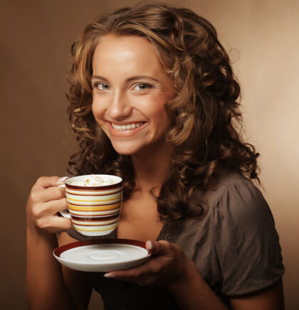 杯子喝着茶或咖啡的漂亮女孩马克杯享受卷发