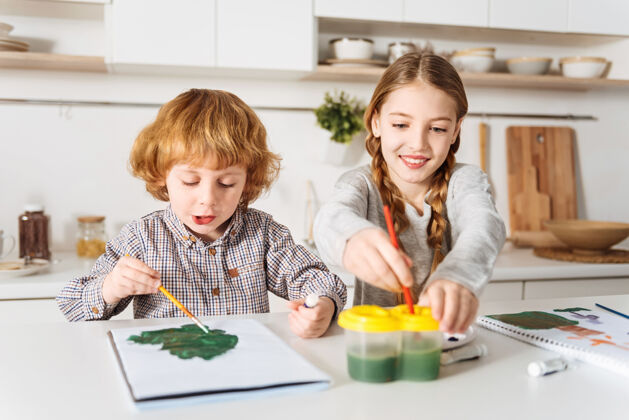人才我们该怎么办下一个令人钦佩热情明亮的孩子们在一起度过周末 坐在厨房的桌子旁 享受着绘画的乐趣发展休闲水彩画