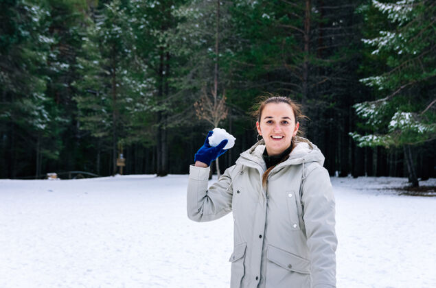 活力在自然的雪景中扔雪球的女人动作天气战斗