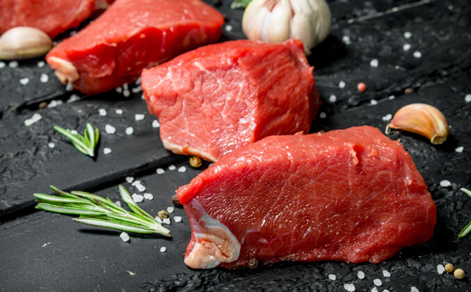 牛排生的肉切片的在木板上放几块牛肉和香料和香草鱼片肉新鲜