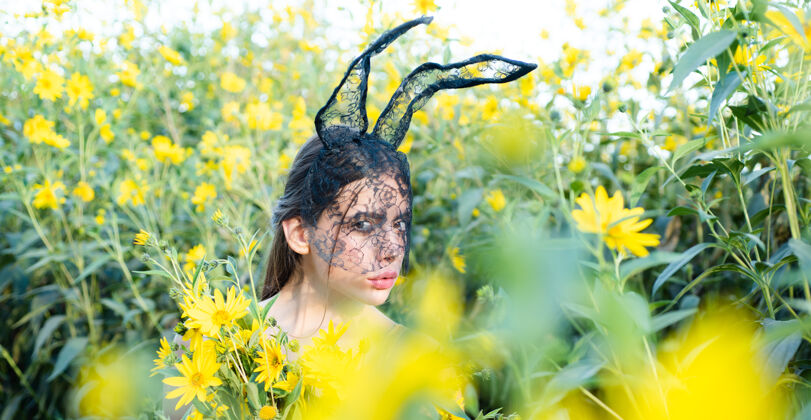 表情戴着兔子耳朵过复活节的快乐的年轻女人鸡蛋兔子兔子耳朵服装礼物有趣兔子