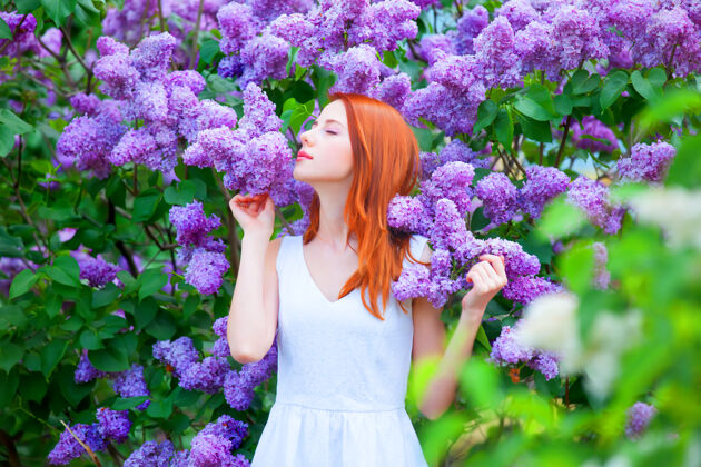 裙子花园里紫丁香树旁的红发女孩姿势梦感性