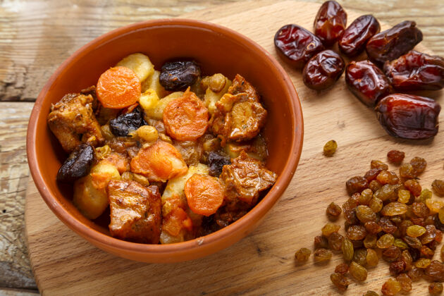 熟食犹太料理的菜是在黑色的盘子里放上红枣 胡萝卜和火鸡肉以色列传统自然