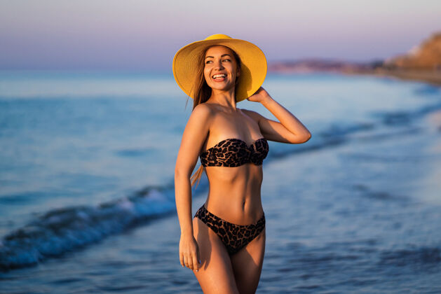 漂亮漂亮的黑发女人在海边的海滩上放松太阳海洋海洋