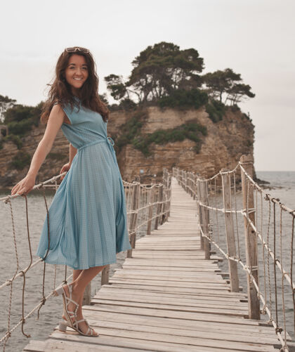 森林年轻快乐的女人在海边的桥上地平线放松热带