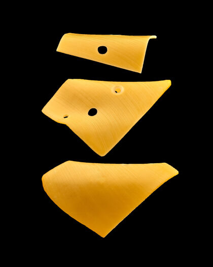 切达黄色的奶酪在黑色的飞机上飞舞奶酪食物