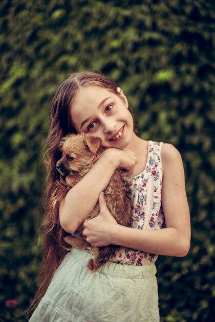 孩子一个金发小女孩带着她的宠物狗在外面停车场女孩喜欢一只小狗童年友谊狗