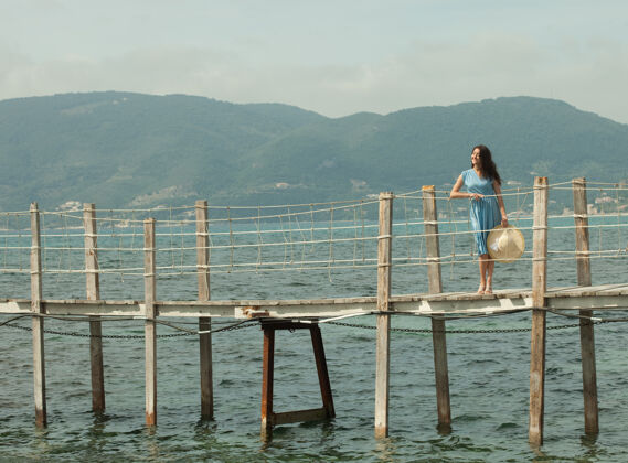 浪漫年轻快乐的女人在海边的桥上 夏日时光码头码头热带