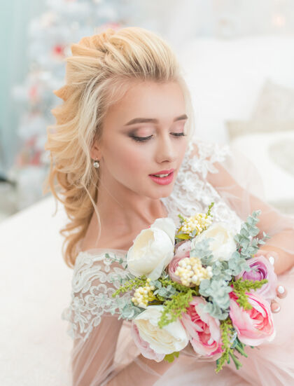 礼服年轻美丽的时尚新娘在冬季装饰与花束在她的手中室内成人婚礼化妆