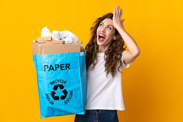 年轻年轻女子拿着一个装满废纸的回收袋去回收隔离在黄色上的东西 已经意识到了什么 并打算解决这个问题再利用实现女性