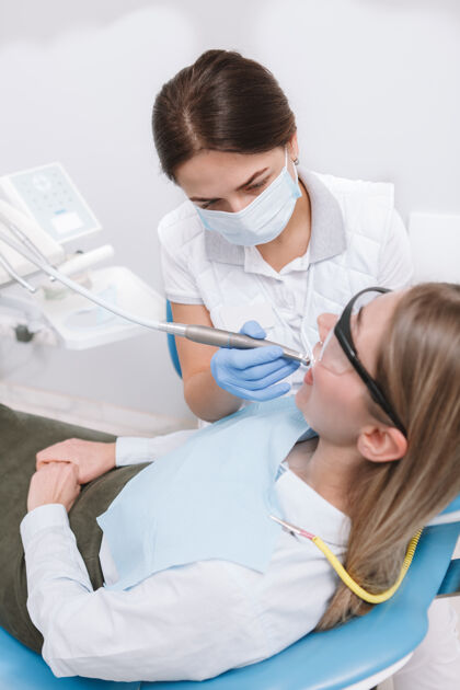 微笑垂直俯视图拍摄的女牙医与病人一起工作医学诊所女人