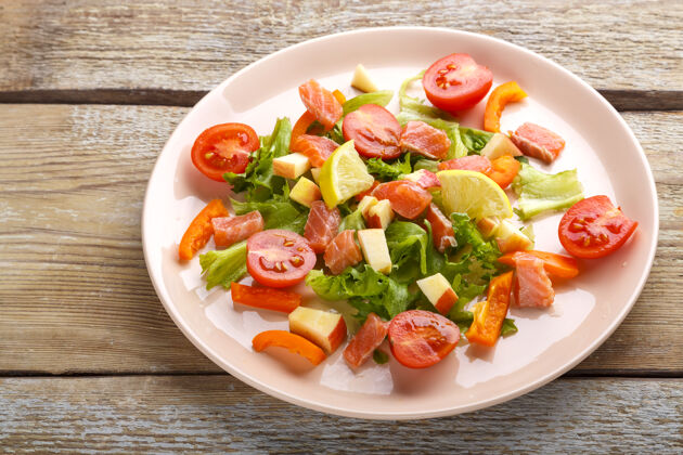 菠菜在木桌上的盘子里放上三文鱼和樱桃西红柿沙拉和蔬菜沙拉蔬菜肉类新鲜