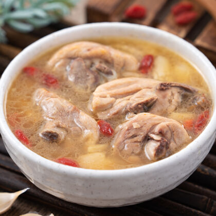 碗台湾菜-自制美味的蒜味鸡汤放在一个碗里 背景是深色的木桌菜特写木头