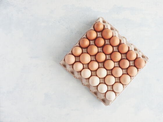 集装箱纸箱鸡蛋盒与许多棕色鸡蛋在不同的颜色和降解色调俯视图平铺纸板鸡蛋纸箱