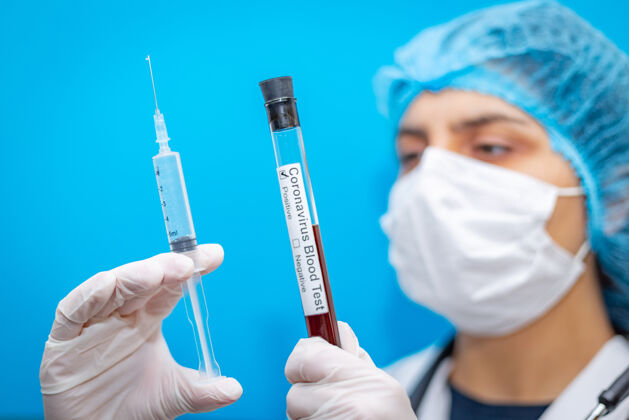 血液测试医学实验室血液试管和注射器在一个年轻的病毒学家女医生手中传播感染药物