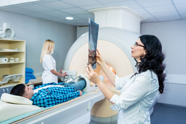 科学放射科医生和一个男性病人一起检查核磁共振扫描实验室癌症医院