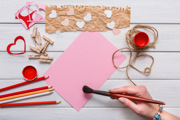 创造手工礼品贺卡创作 画红心 工艺纸和diy工具上的白色木材浪漫卡片婚礼